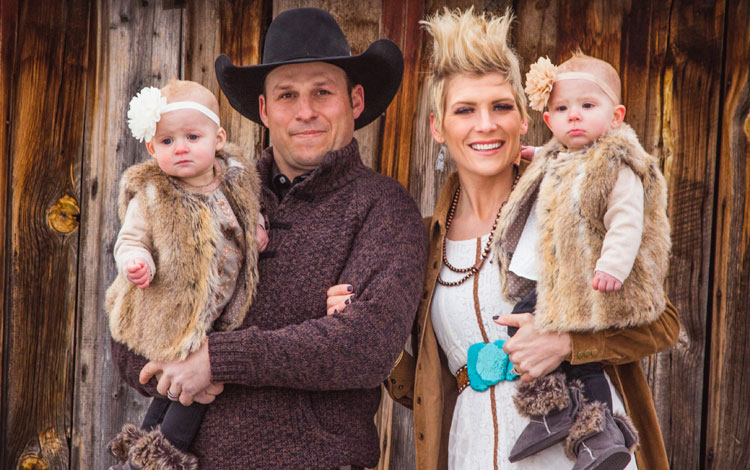 A family photo in front of an old barn.